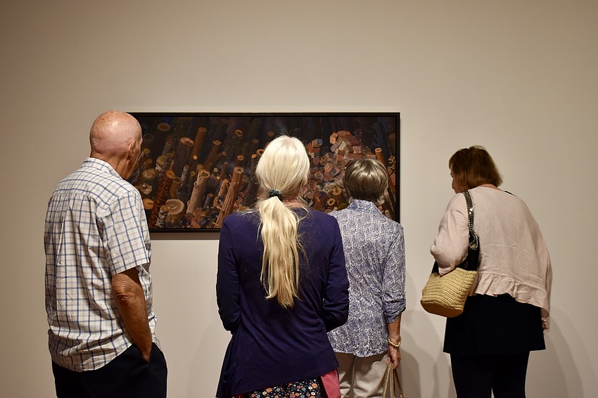The docent offers more information to group members about the artwork.