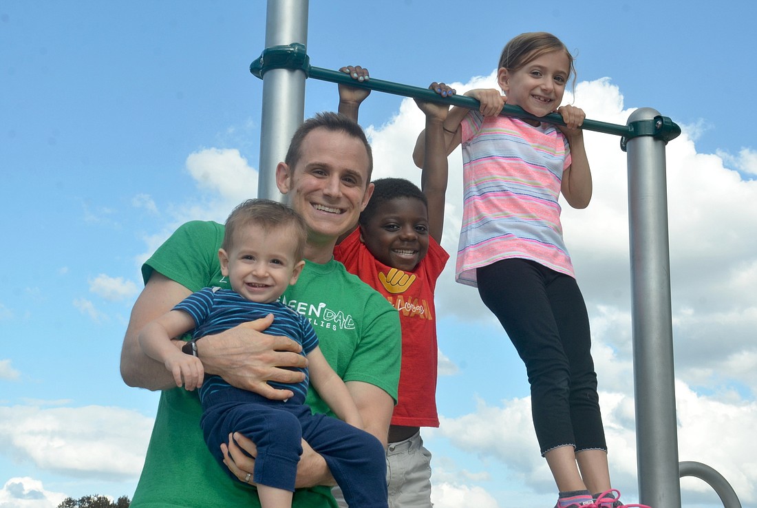 Cory Warren and his son, Parker, enjoy a nice day at the park, while siblings Rog and Izzy get some pull-ups in.