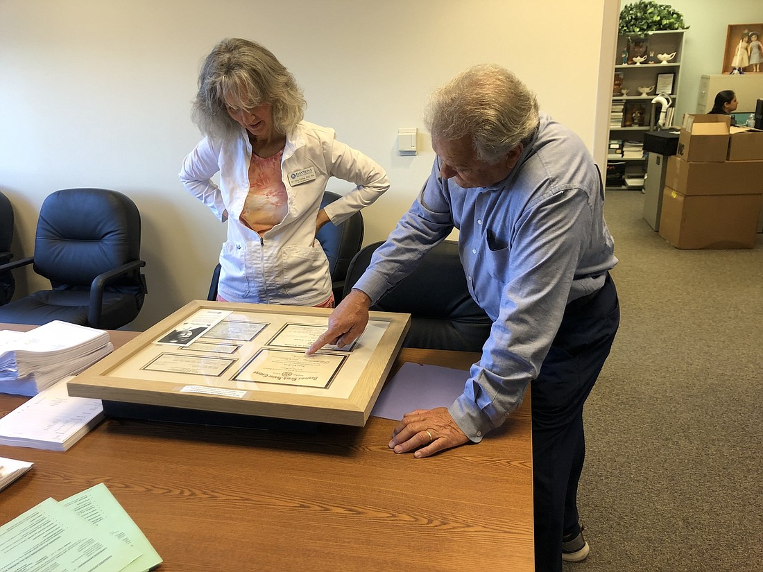  Dr. Larry Petker shows Amy Szoka, of Daytona State College, some of his wife Sandi's memorabilia for a shadowbox. Courtesy of Dr. Larry Petker