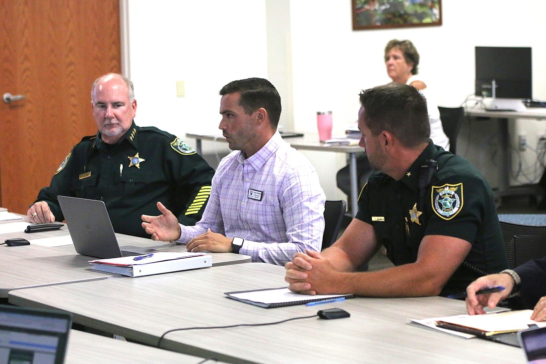 District safety specialist Tom Wooleyhan, center, explains the guardian program while Sheriff Rick Staly, left, and Commander Jason Neat look on. Photo by Brent Woronoff