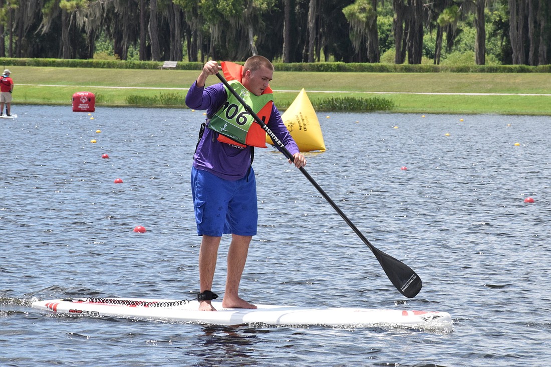 Lee County’s Terry Johnson participates in a preliminary round of the Special Olympics Stand-up Paddleboard Championship.