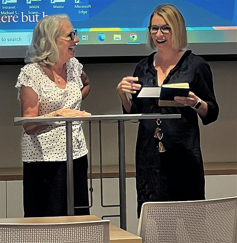 Michael Saunders & Co. sales associate Kim Ogilvie presents a check to Sandra Chapnick, co-founder of Josh Provides Epilepsy Assistance Foundation. (Photo courtesy of MSC Foundation)