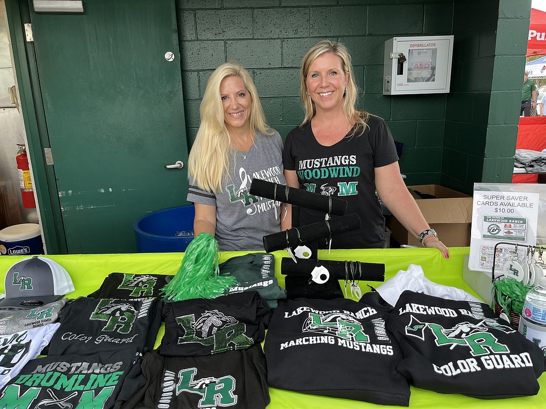 Heidi Gillen and Melody Filewich sell Lakewood Ranch High School Marching Mustangs merchandise during a football game. Merchandise is one way band parents raise money for the school&#39;s band program.