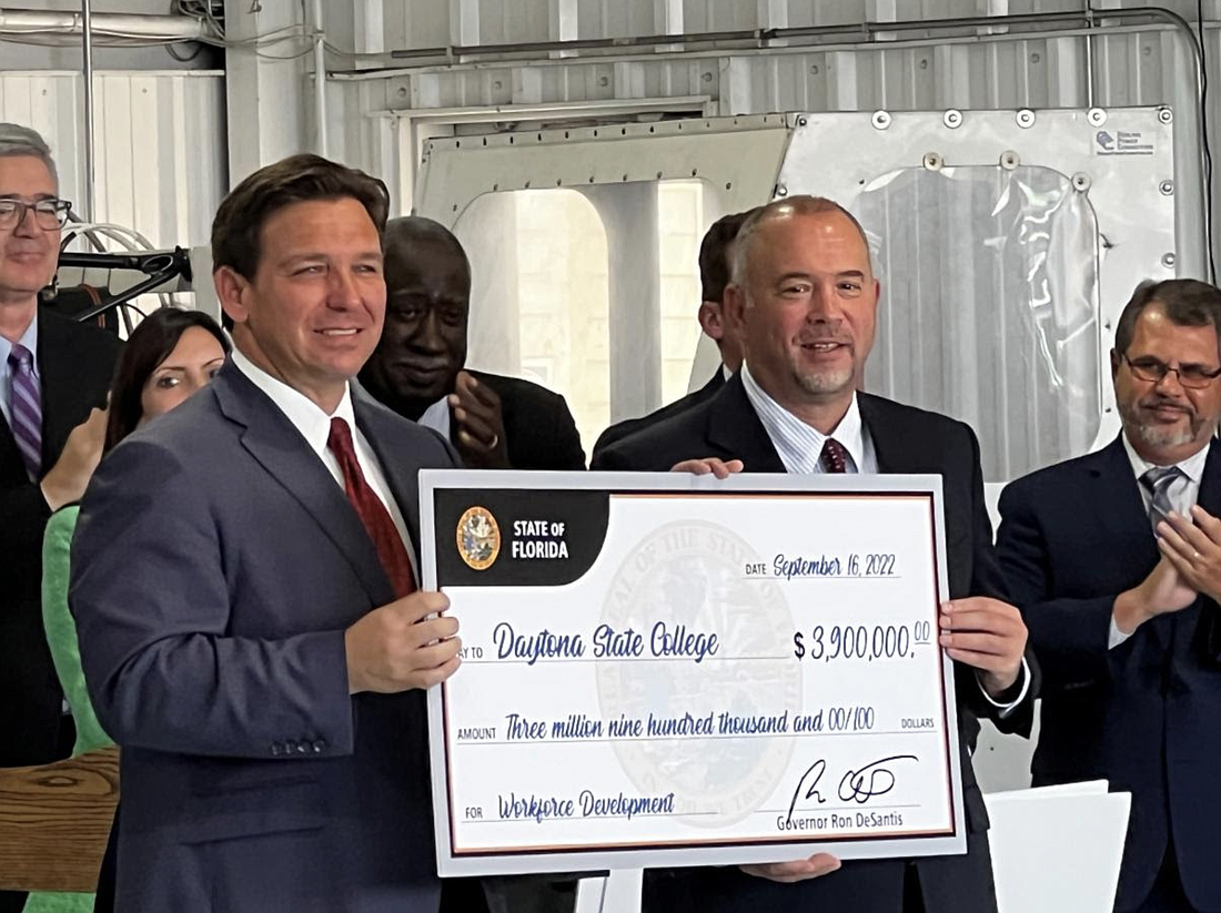 Florida Gov. Ron DeSantis (left) presents a $3.9 million check to DSC President Tom LoBasso. The state is also awarding an additional $1.3 million for creation of a CDL training program. Photo courtesy of Daytona State College
