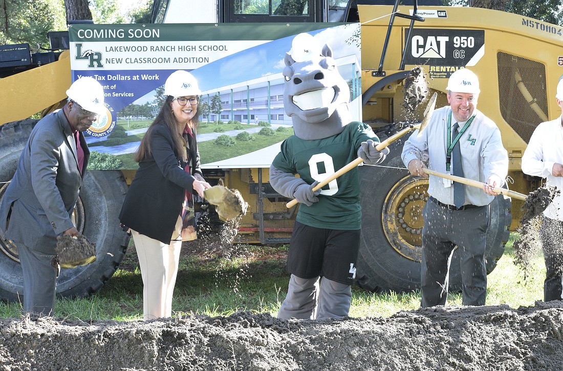 School Board member James Golden, Superintendent Cynthia Saunders, Lakewood Ranch High School&#39;s mascot and Lakewood Ranch High Principal Dustin Dahlquist move dirt for the groundbreaking. (Photo by Liz Ramos)