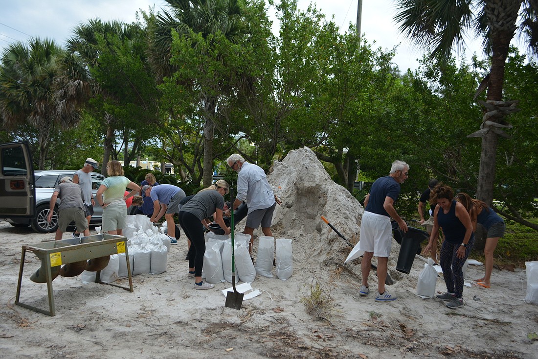 Longboat Key residents gather at the Broadway Beach Access on Sept. 25, 2022, to fill sandbags ahead of Hurricane Ian.