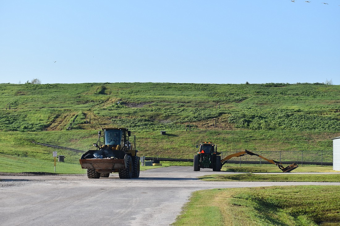 Construction vehicles navigate the landfill on Lena Road, which is adjacent to the rezoned area. (Photo by Ian Swaby)