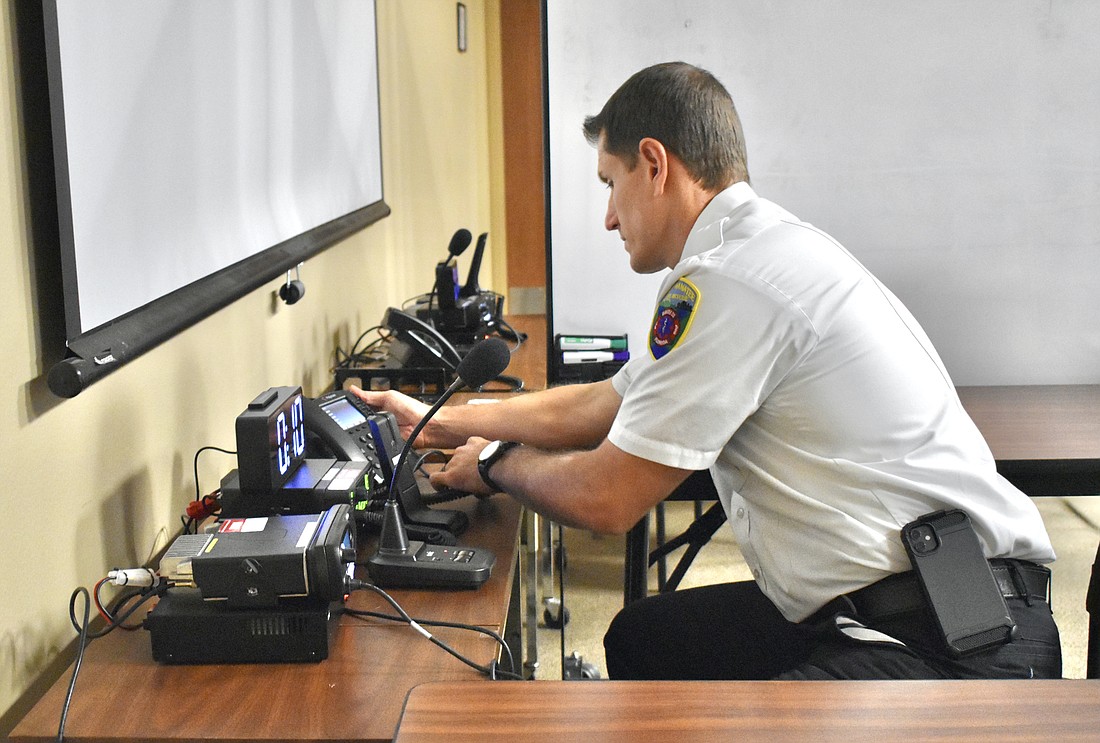Deputy Chief William Hall sets up the emergency call center at East Manatee Fire Rescue Station 1, which will handle overflow from the Emergency Operations Center. (Photo by Ian Swaby)