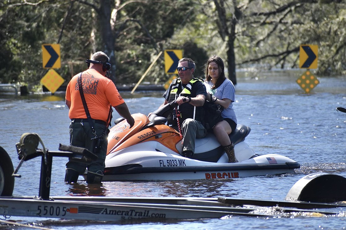 Manatee Search and Rescue staff members T.J. Olsen and Jared Leggett rescue a woman trapped in her Myakka City home on Singletary Road by rising waters during Hurricane Ian.