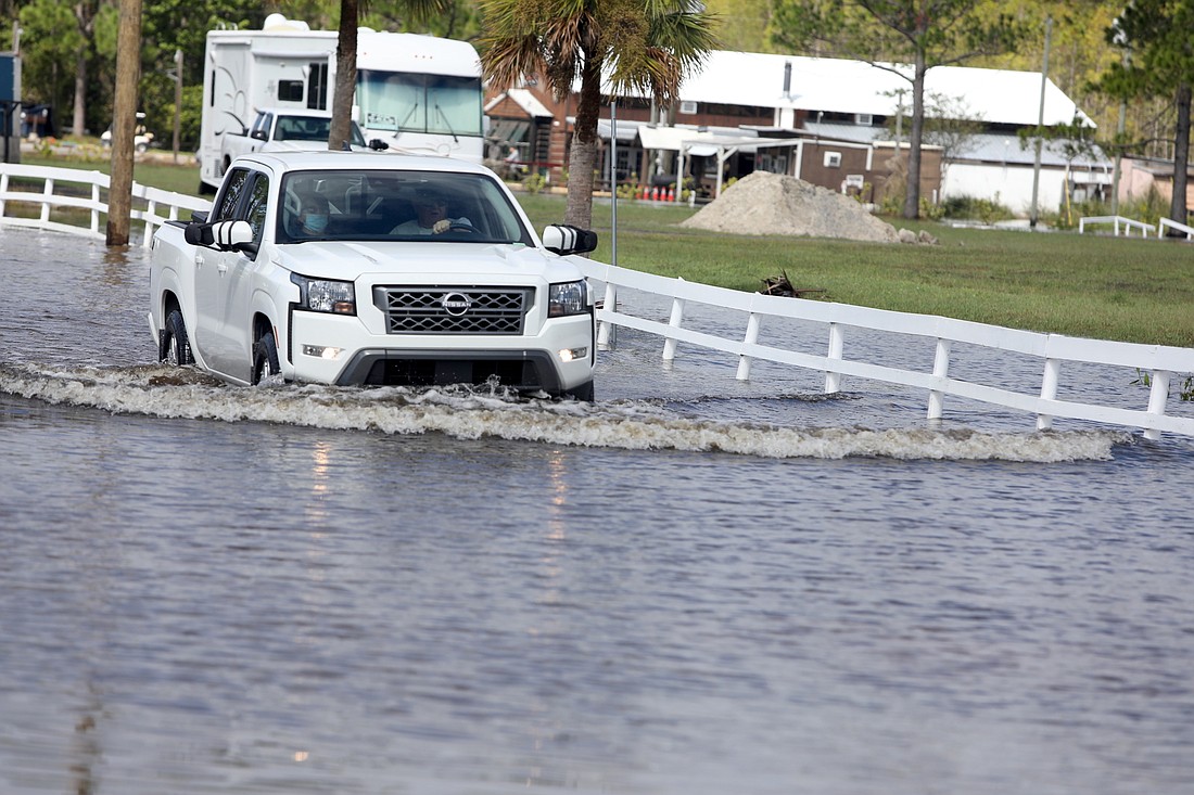 A truck exits the flooded road leading to Tomahawk Tavern on U.S. 1 in Bunnell on Friday, Sept. 30. Photo by Brent Woronoff
