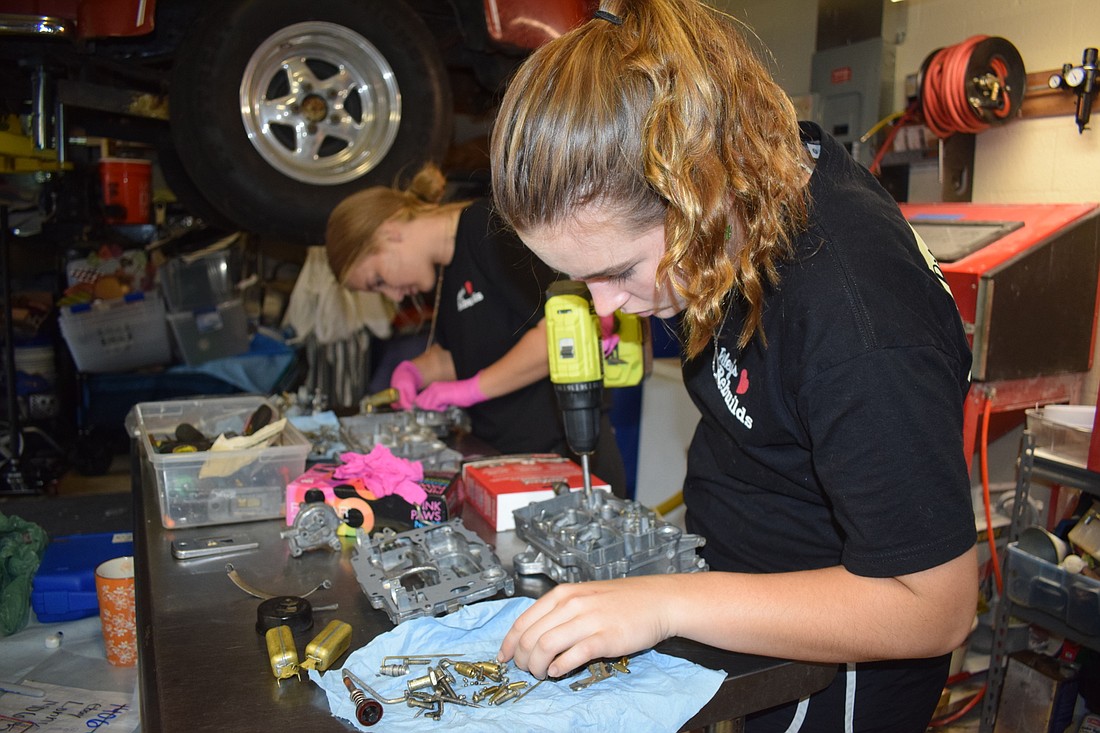 Riley Schlick-Trask works on rebuilding a carburetor in her family&#39;s garage in Lakewood Ranch. (Photo by Jay Heater)