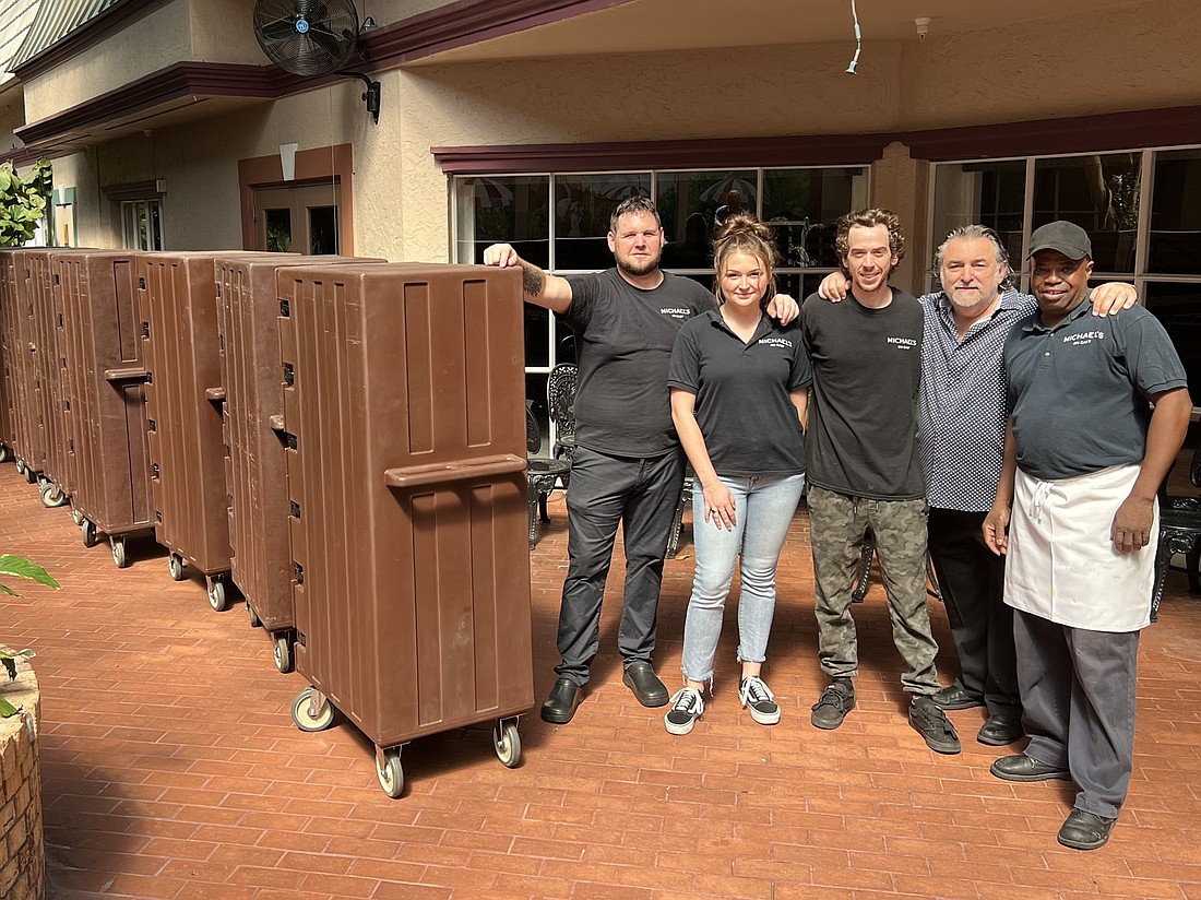 Michael&#39;s On East staff  Scott West, Margaux Arthur, Matt Merriman, Co-Proprietor Phil Mancini and Lavardo Morely stand next to food crates ready for delivery. The restaurant made more than 3,000 meals by noon Sept. 30.