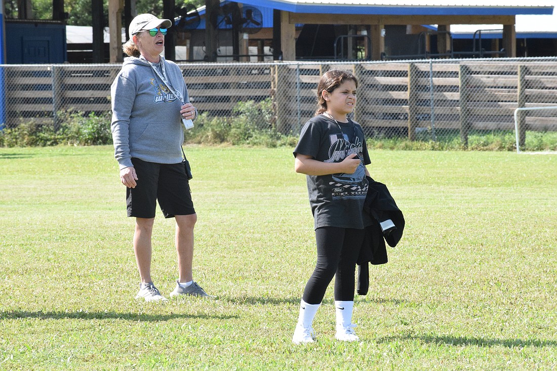 P.E. teacher Bet Tracy and sixth grader Leah Lazarde watch students as they play gator ball. (Photos by Liz Ramos)