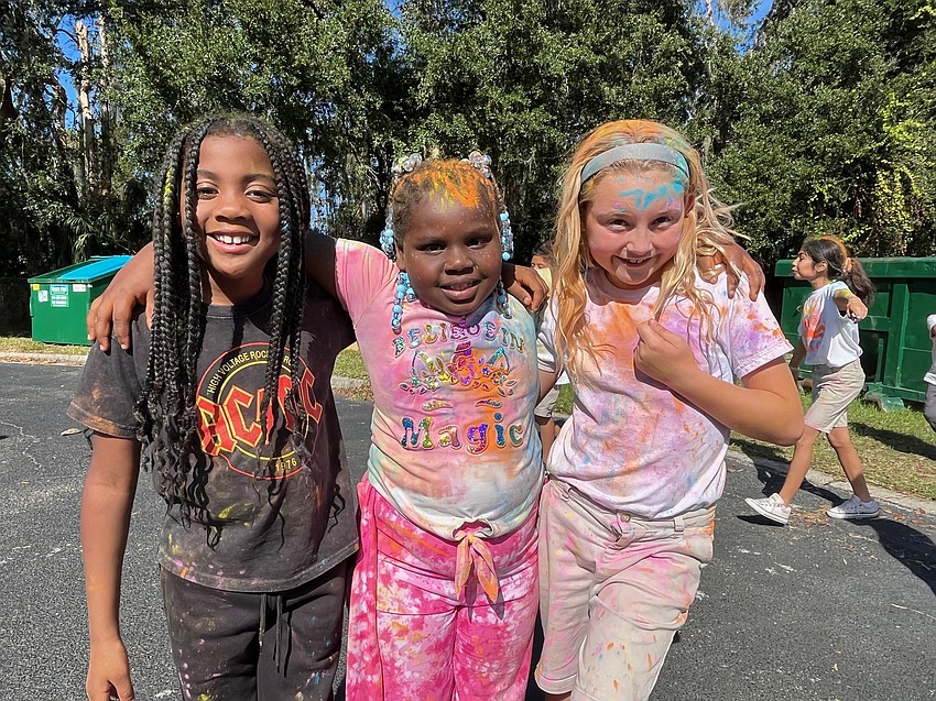 Kindergartner Jalaysia Blackman has fun at the color run with third graders Kaliyah Pontoon and Kylie Burton.