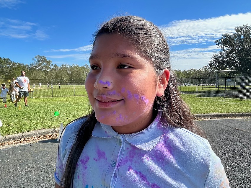 Fourth grader Maria Sanchez gets purple paint all over her face.