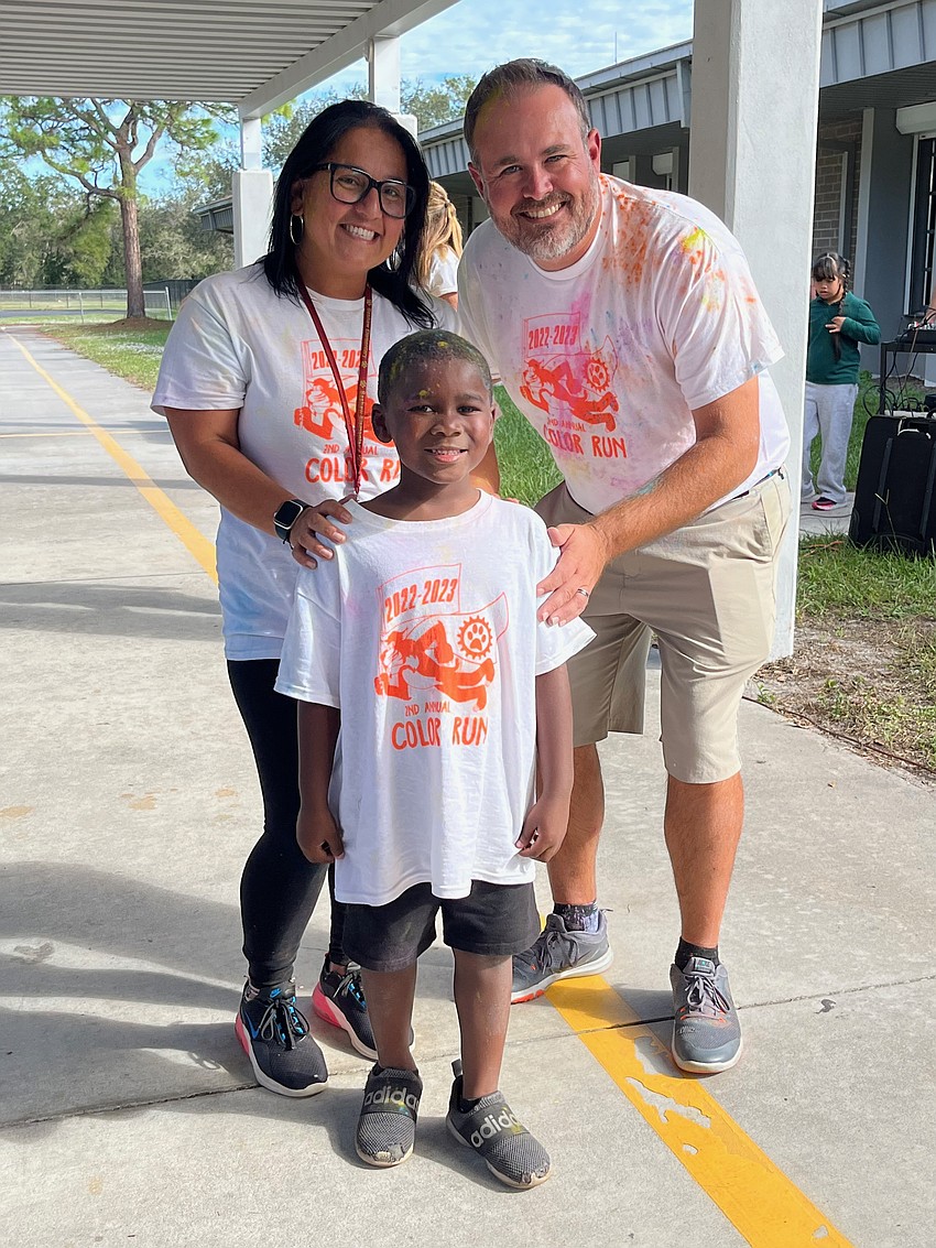Assistant Principal Maria Gil and Principal James Dougherty congratulate kindergartner Christopher Taylor Jr. for being the individual to raise the most money. Taylor raised $290.