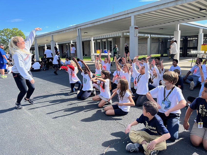 Third grade teacher Valerie Garber leads the third graders doing the wave.