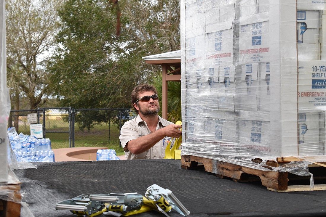 Manatee County Public Works Fleet Services employee Christopher Brooks unloads containers of bottled water.
