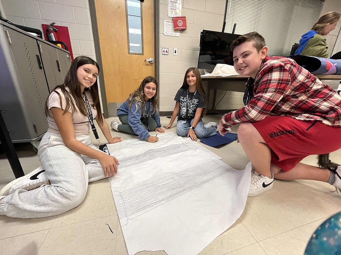 Eighth graders Leah Duff, Juliana Fuschetto, Elena Margioukla and Vincenzo Pino work on decorations for a trick-or-treat station. (Photo by Liz Ramos)