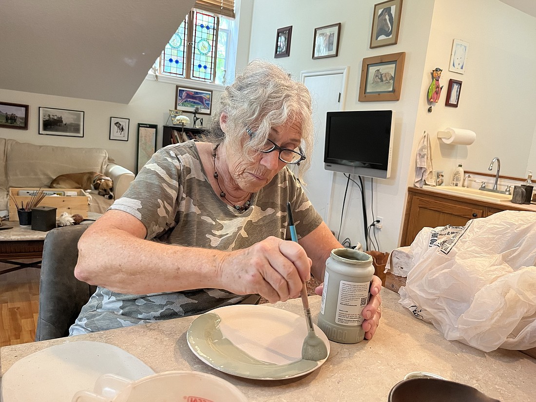 Panther Ridge&#39;s Denise Millett-Olverson loves being able to choose what glazes, colors and designs to use on her pieces. (Photo by Liz Ramos)