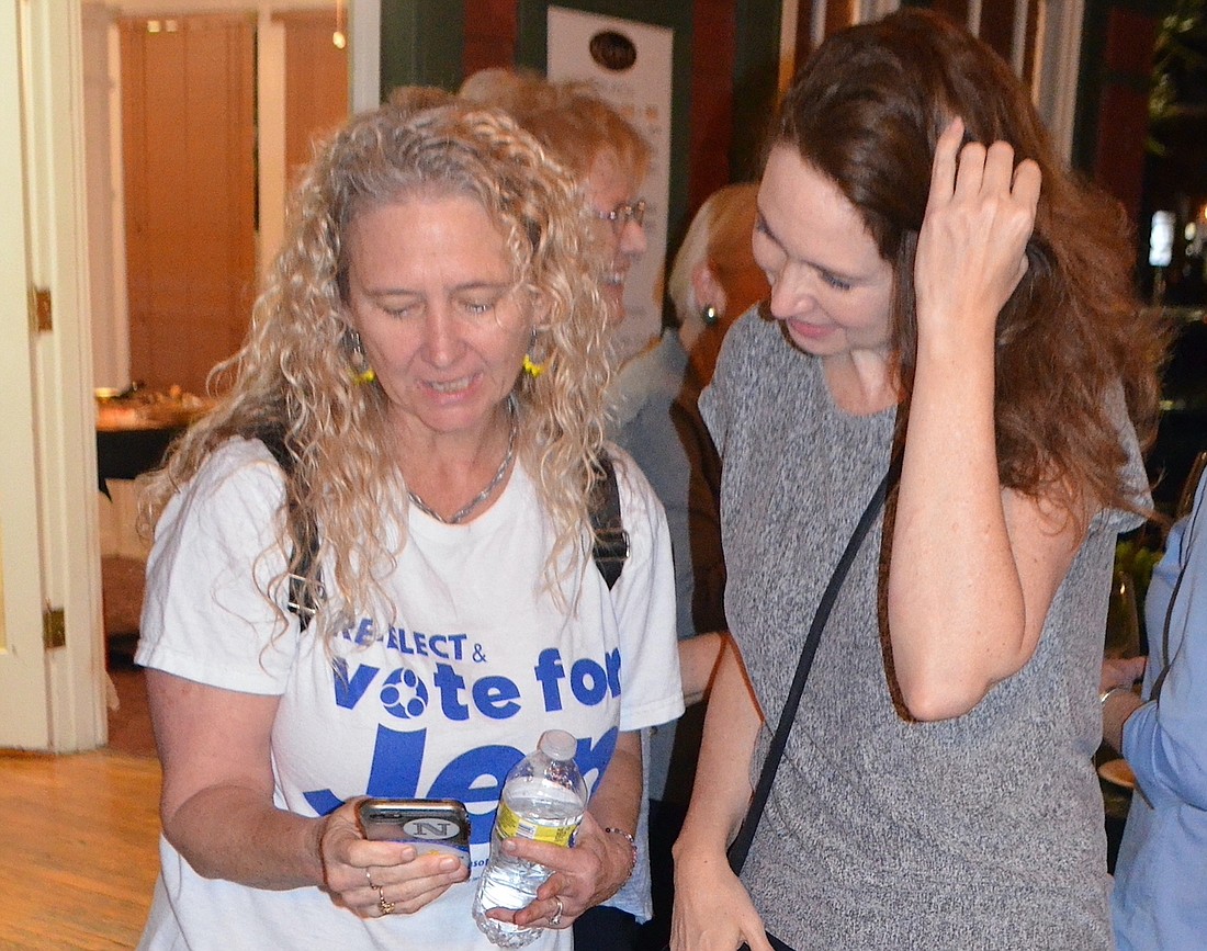 The top vote-getter among three candidates, incumbent Jen Ahern-Koch checks election returns with a supporter at her celebration Tuesday night. (Andrew Warfield)