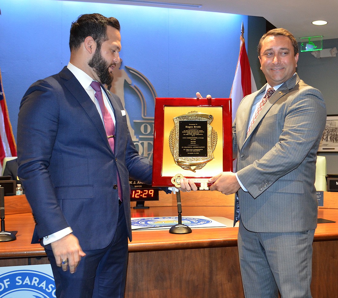 In one of his final official acts as mayor of Sarasota, Erik Arroyo (left) presents outgoing City Commissioner Hagen Brody with a plaque commemorating his service to the city as commissioner and former mayor. (Andrew Warfield)