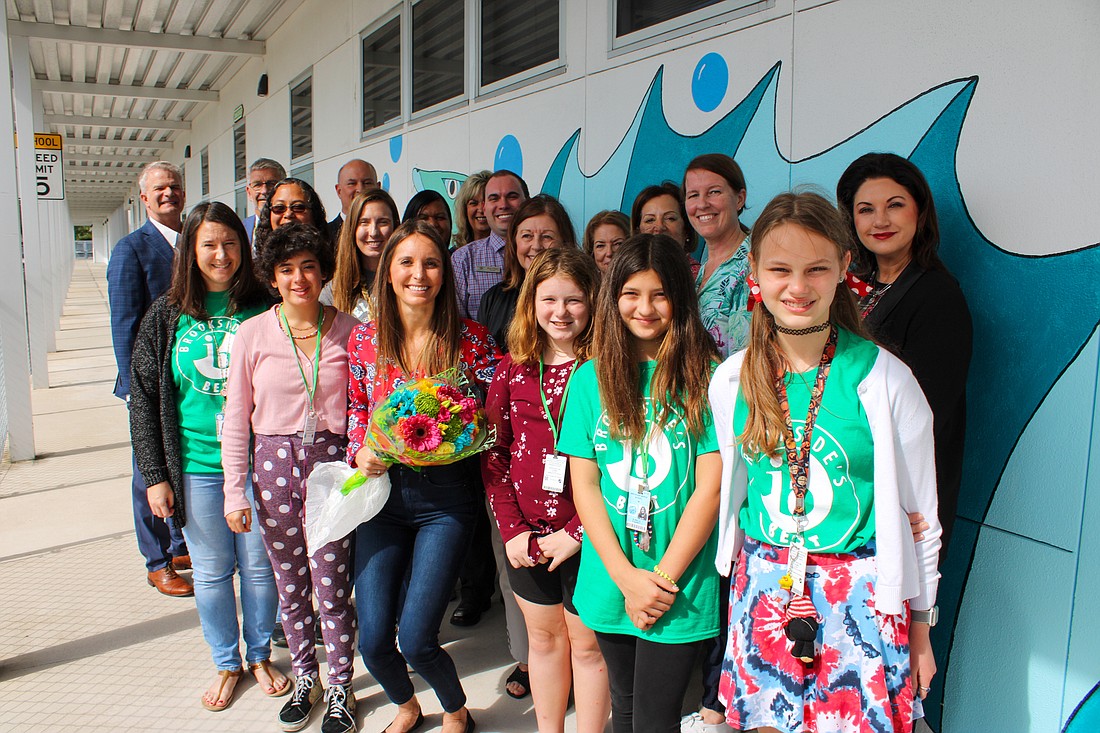  Jessica Fuesy, center, is congratulated by students, staff and school district officials at Brookside Middle School. (Courtesy image)