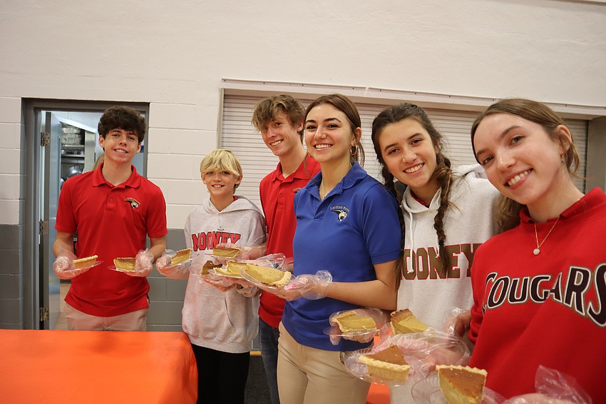 Nathan Sutthoff, Lucas Hassler, Grant Yeagley, Piper Yegley, Lauren Martinez, Ellie Martinez hold slices of pumpkin pies