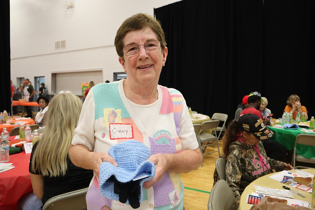 Ginny Hoenig holds one of her handmade crocheted hats.