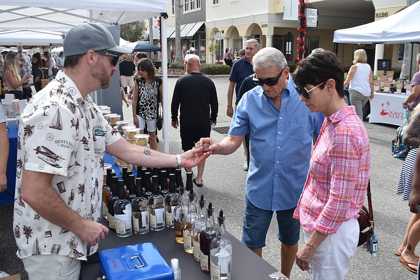 Dave Sarka of Siesta Key Rum offers a sample to Riverwalk's Charlie Becraft and Darcy Bevelacoua.