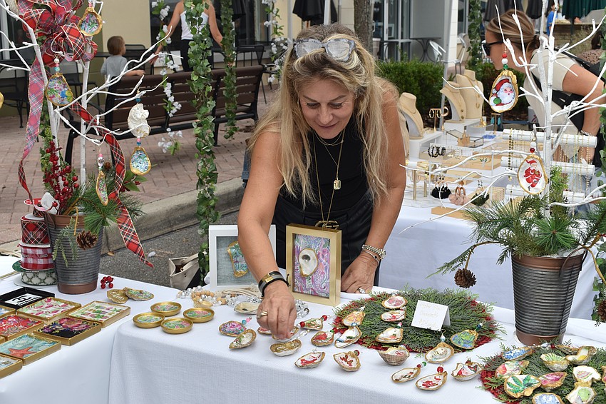 Susan Fisher, owner of SFK Interior Designs & Accessories, arranges Christmas ornaments on the table.