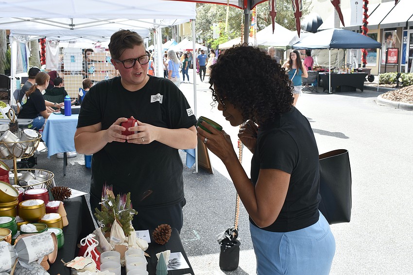 Sarasota's Amy Knapp of SM5 Candle Co. allows Lakehouse Cove's Sonja Harvard to sample the candles.