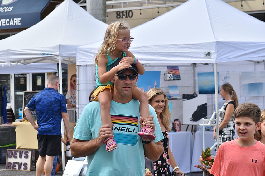 Sapphire Point's 4-year-old Emily Olinger sees the sights from atop the shoulders of her father Matt Olinger.