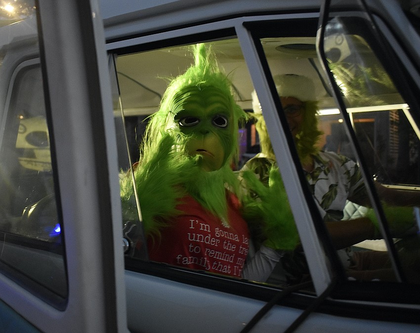 The Grinch throws peace signs in a classic Volkswagen microbus.