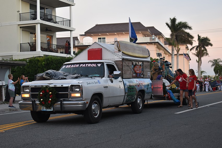 Groups decorate floats with holiday lights in cheery spirit.