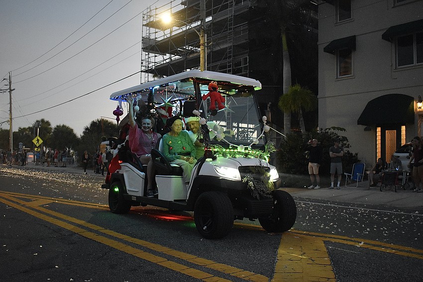 Groups decorate floats with holiday lights in cheery spirit.