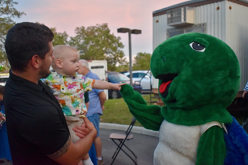 Kyle Tomko holds his nephew Mac Cashin as they meet Shelley the sea turtle.