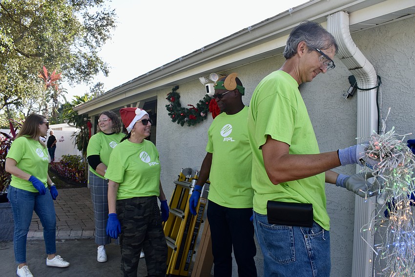 Kaitlyn Kramer, Taylor Wey, Clara Reynardus de Villanueva, Darren Grambrell and Anthony Weimer help each other to hang lights.