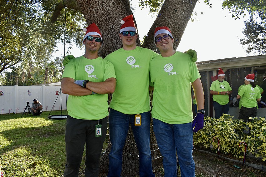 Taylor Garner, Xavier Patrick and Ray Vargas help decorate the front yard tree.