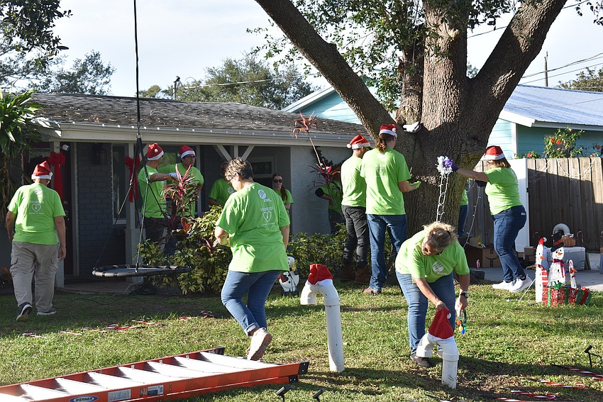 FPL and USF volunteers, a.k.a Elves, get to work on decorating Carlos's front yard.