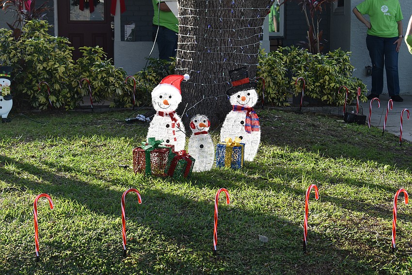 FPL and USF volunteers, a.k.a Elves, get to work on decorating Carlos's front yard.