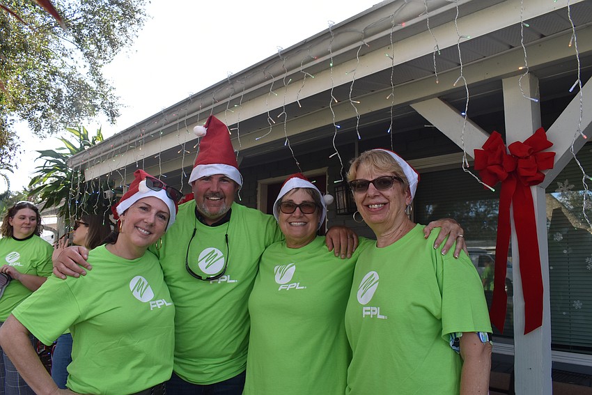 Clara Reynardus de Villanueva, Jay Riley, Marrie Neumer and Pam Gleason decorate the front porch with holiday lights.