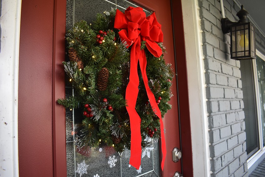 FPL and USF volunteers, a.k.a Elves, get to work on decorating Carlos's front yard