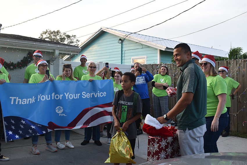 FPL and USF volunteers give gifts to Carlos Jr. Moreira.