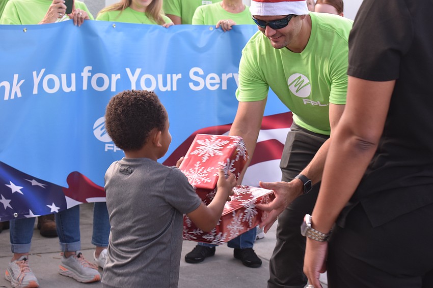 FPL and USF volunteers give gifts to Miguel Moreira.