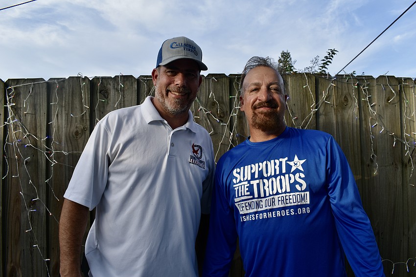 Maverick Johnson and Gary Kortzendorf finish decorating the fence with holiday lights.