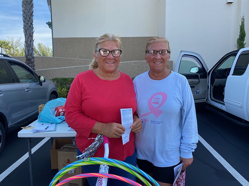 Twin sisters Bonnie Schneider and Annie Pelgen drop off two bags of food and three bags of toys.