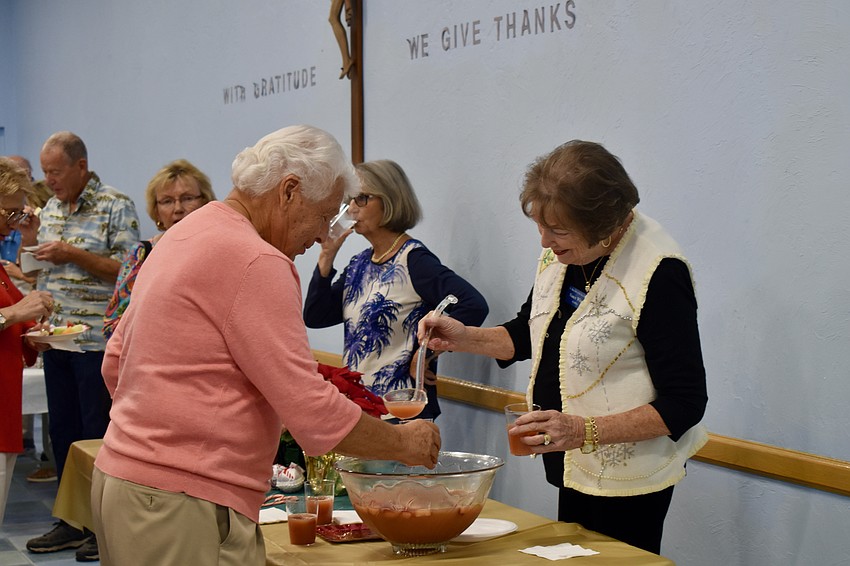 Nancy White pours punch for Tom Vitro.