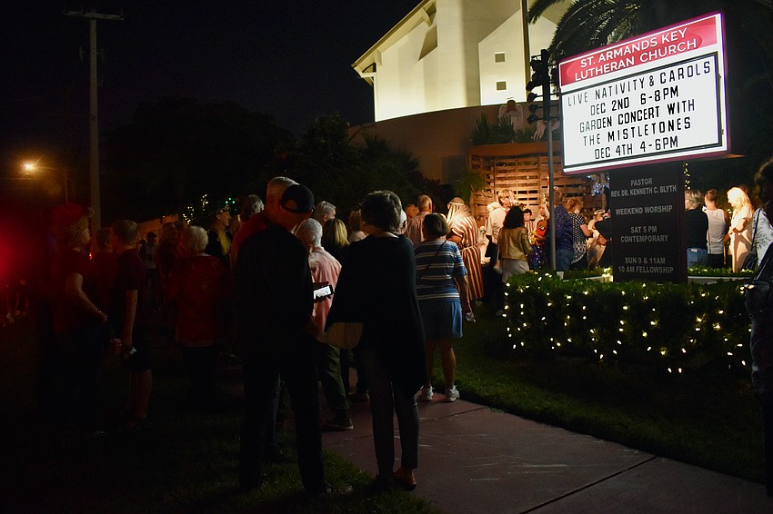 The live nativity draws a crowd on the sidewalk.