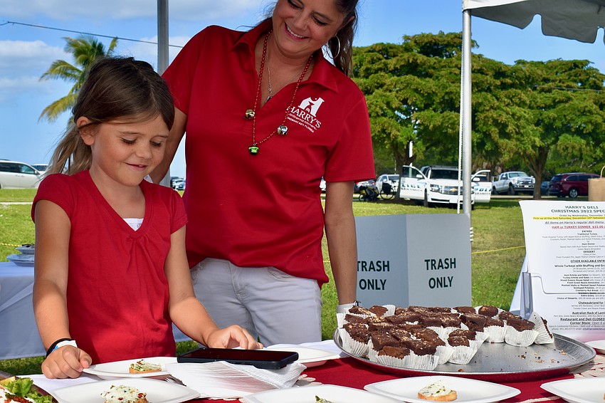 Penelope Hagan helps mom Rachel at the Harry's Continental Kitchens booth.